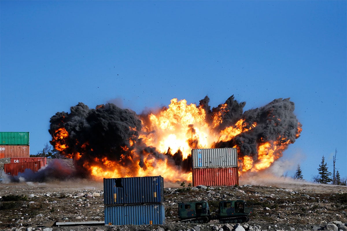 Large explosion behind static container targets, after impact of precision guided bomb