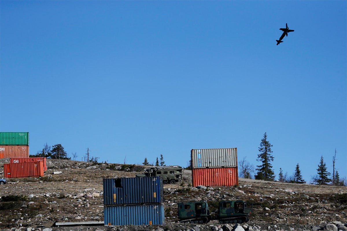 Precision guided bomb in the air, moving towards static container targets on the ground
